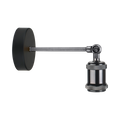 A modern wall-mounted microscope with a matte black circular base, a long adjustable metal arm, and a textured knurled collar on the objective lens, shown against a solid white background.