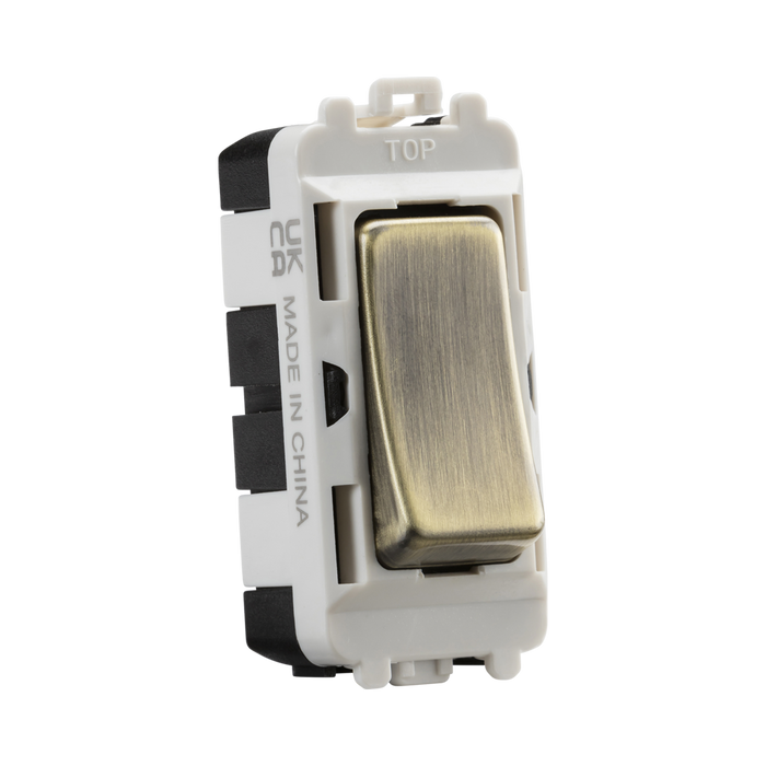 Toggle switch with brass rocker and white frame on a white background