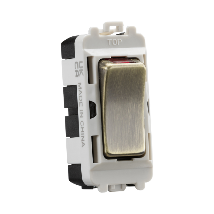 Electrical switch with brass rocker and white housing on a white background