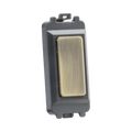 Brass switch with a gold faceplate on a white background