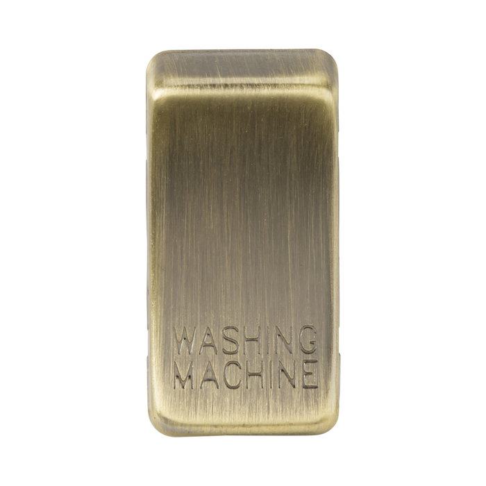 Rectangular brass object with 'Washing Machine' engraving on a white background