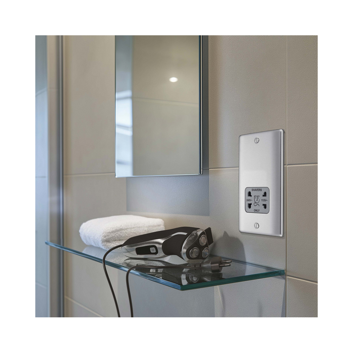 Metallic wall outlet with shaver socket label on a white background bathroom setting
