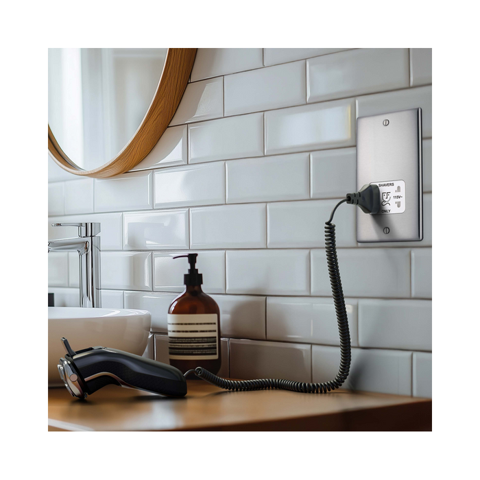 Metallic wall socket with shaver outlet label on a white background bathroom setting