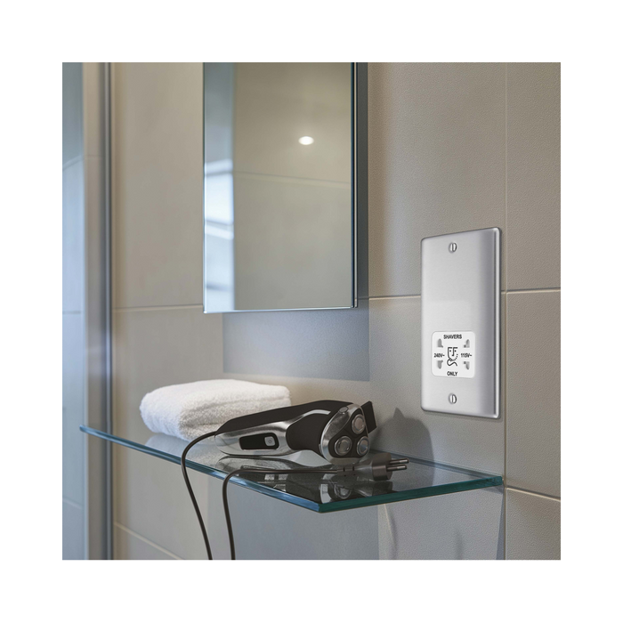 Metallic wall socket with shaver outlet label on a white background bathroom setting