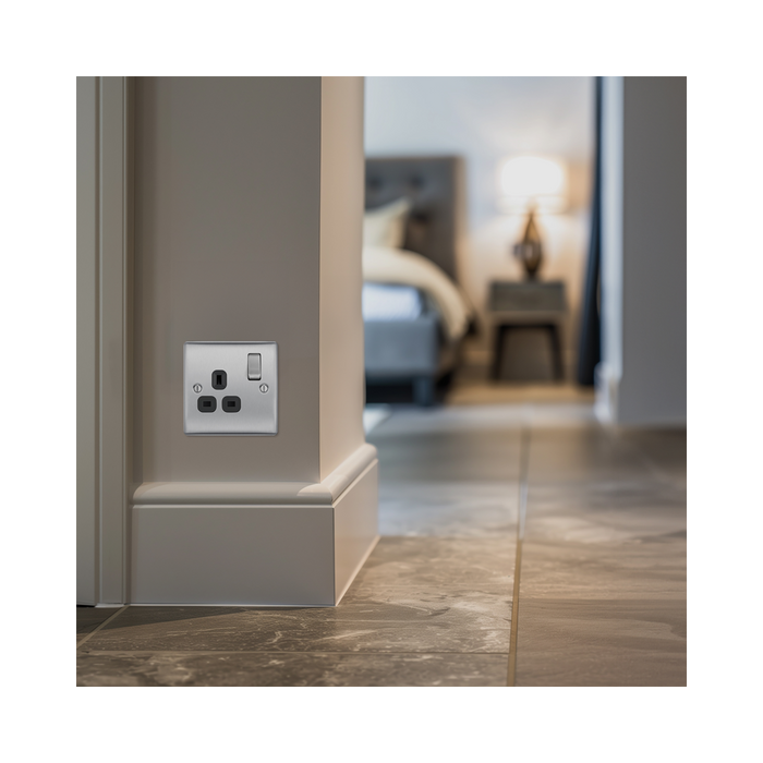 Metallic electrical socket with black inserts on a white background bedroom setting