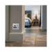 Metallic electrical socket with black inserts on a white background bedroom setting