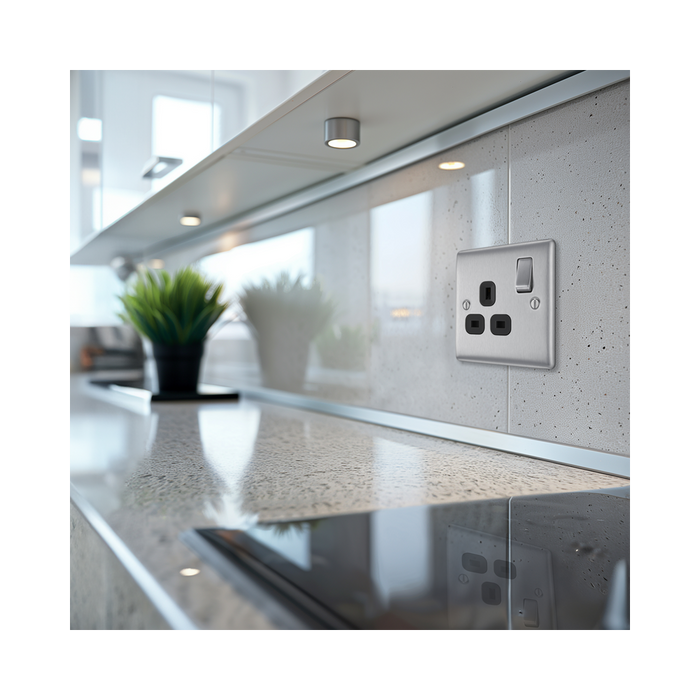 Metallic electrical socket with black inserts on a white background kitchen setting