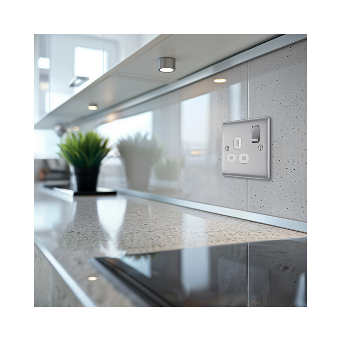 Metallic light switch with socket on a white background kitchen setting