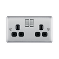Metallic electrical socket with two black outlets and two silver rocker switches on a white background