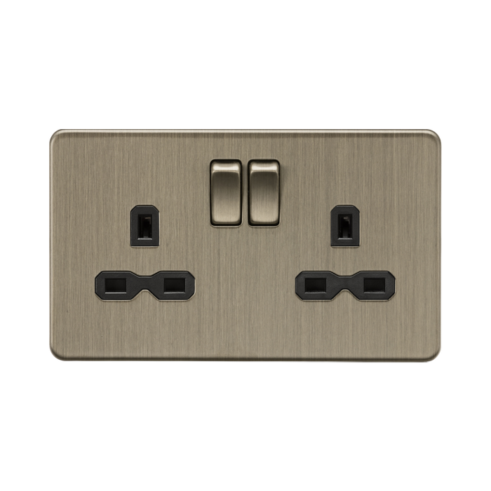 Antique Brass electrical socket with two black plug sockets and a double switch on a white background