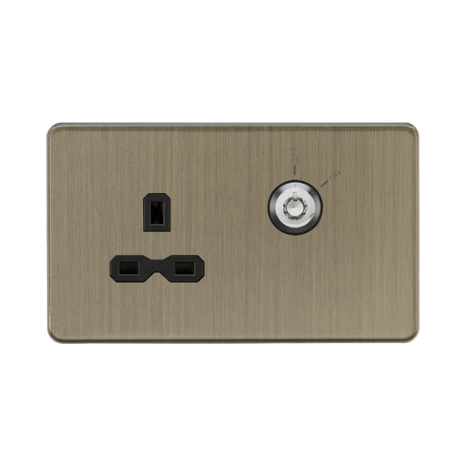 Antique Bronze wall socket with black outlets and plug on a white background